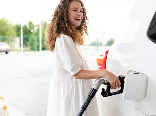 L’immagine di una ragazza sorridente in macchina rappresenta la felicità di un dipendente nell’utilizzare la nostra soluzione del Buono Acquisto Benzina Pluxee.Alt text